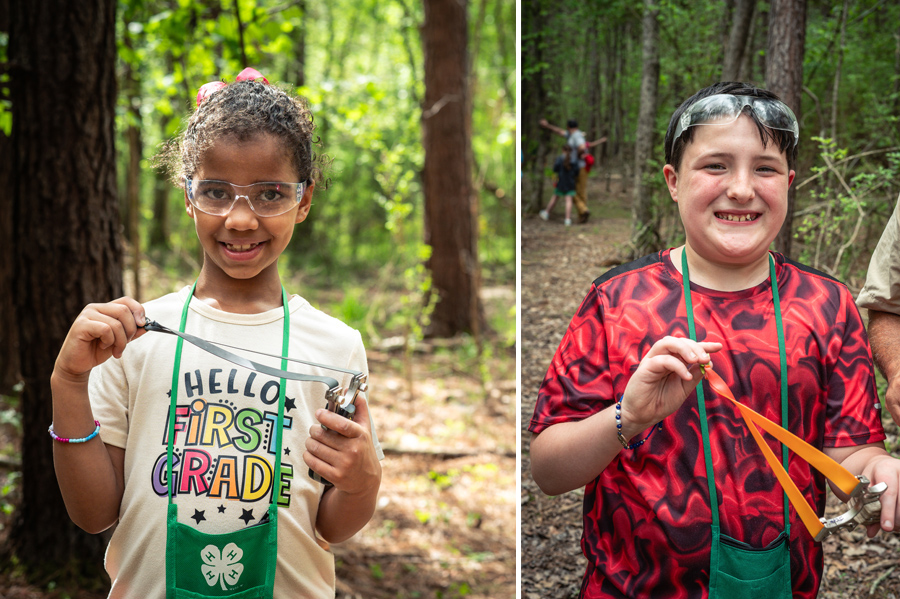 A girl holding a slingshot and smiling, and a boy holding a slingshot and smiling.