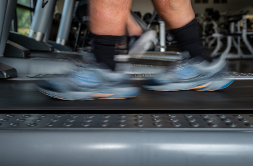 Closeup of a person’s shoes in blurred motion on a treadmill.