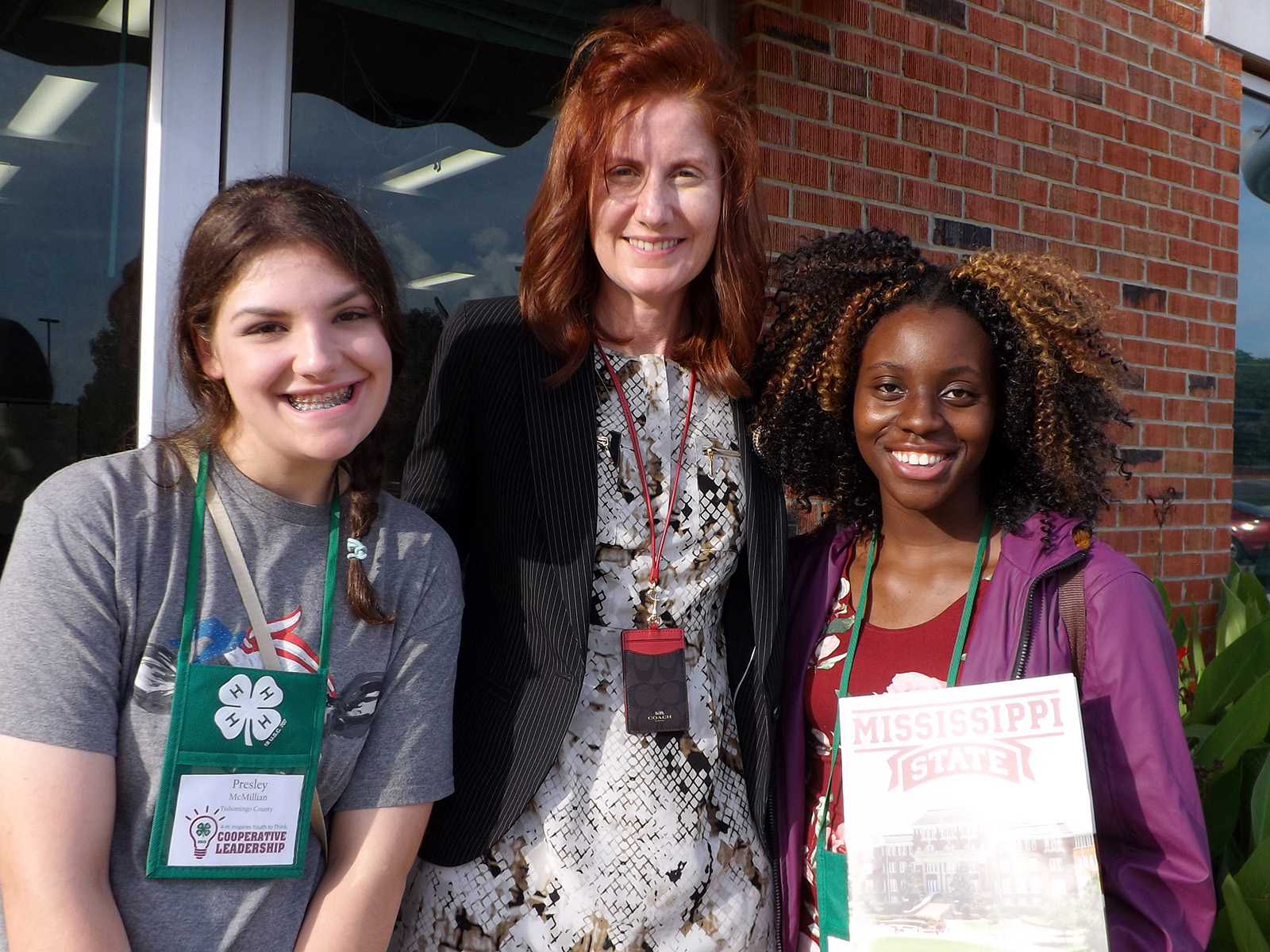 A woman and two girls pose for camera.