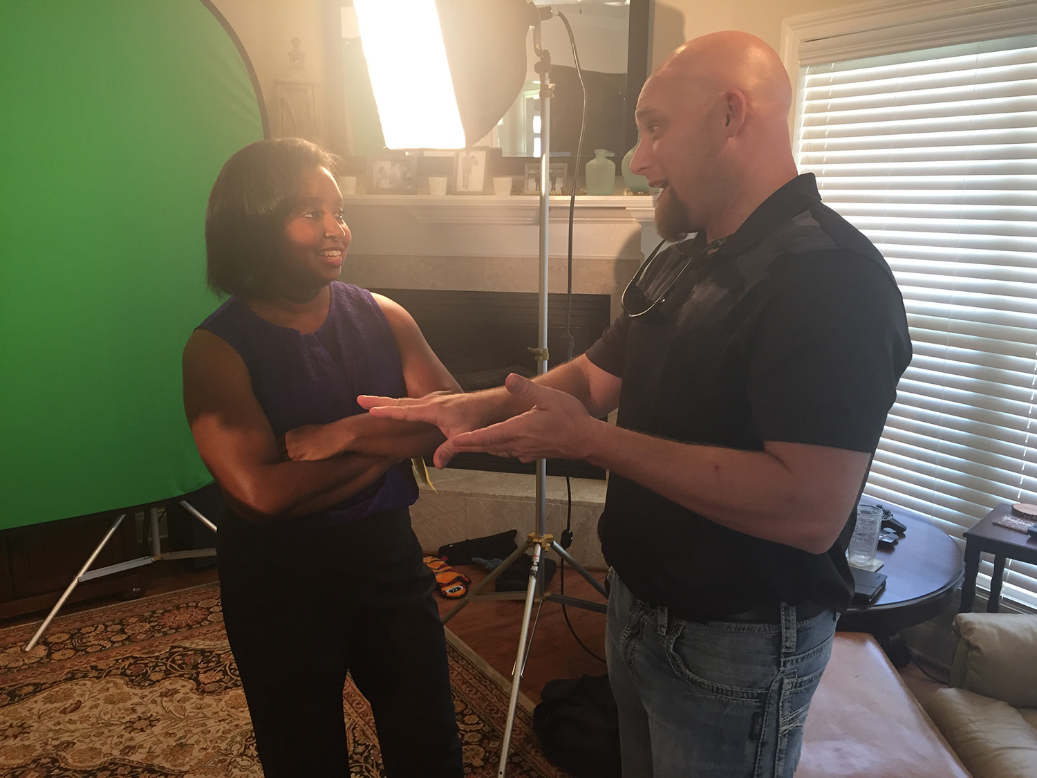 Host Natasha Haynes stands beside executive producer Brian Utley discussing the next shot.