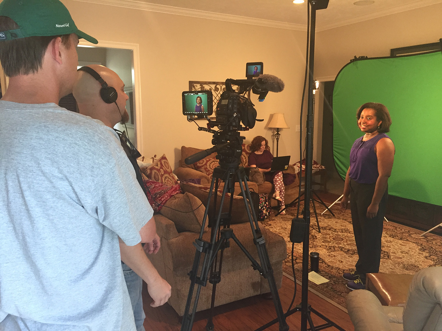 Host Natasha Haynes stands in front of a green screen filming a scene for The Food Factor.