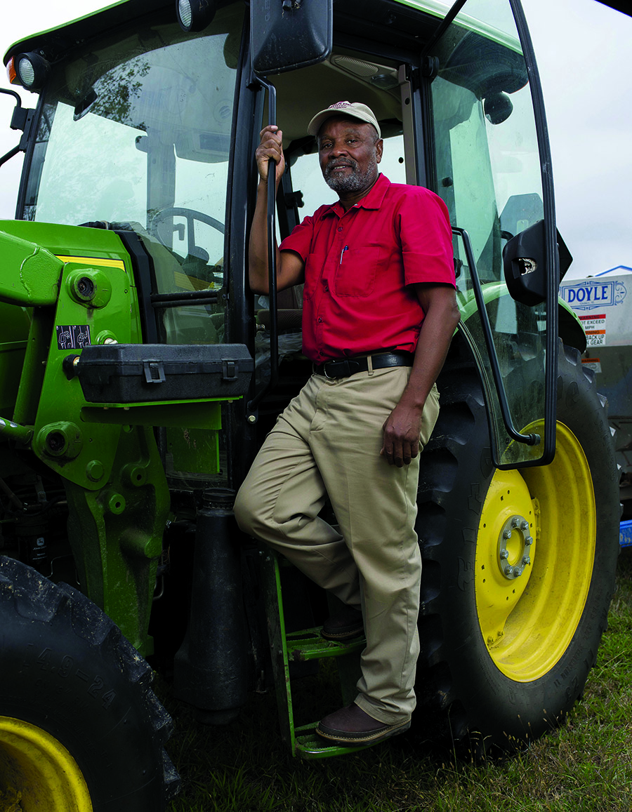 A man standing in the door of a tractor.