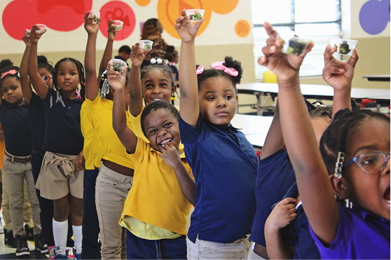 A group of smiling children in a school cafeteria.