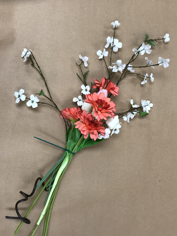 Cluster of fake pink and white flowers held together by a zip-tie.