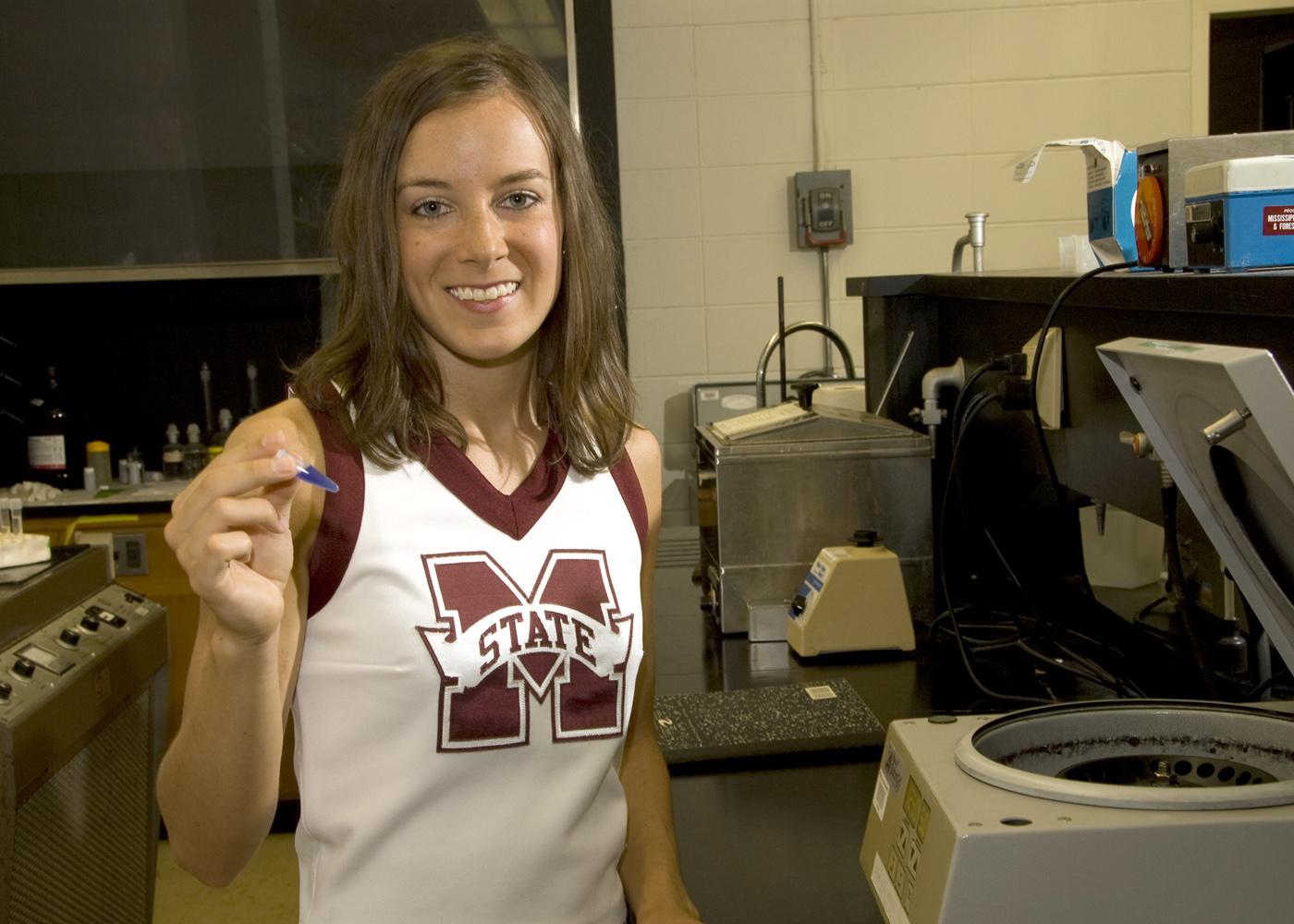 Lauren Beatty is equally at home on the football as a Mississippi State University cheerleader and in the science laboratory. (Photo by Marco Nicovich)