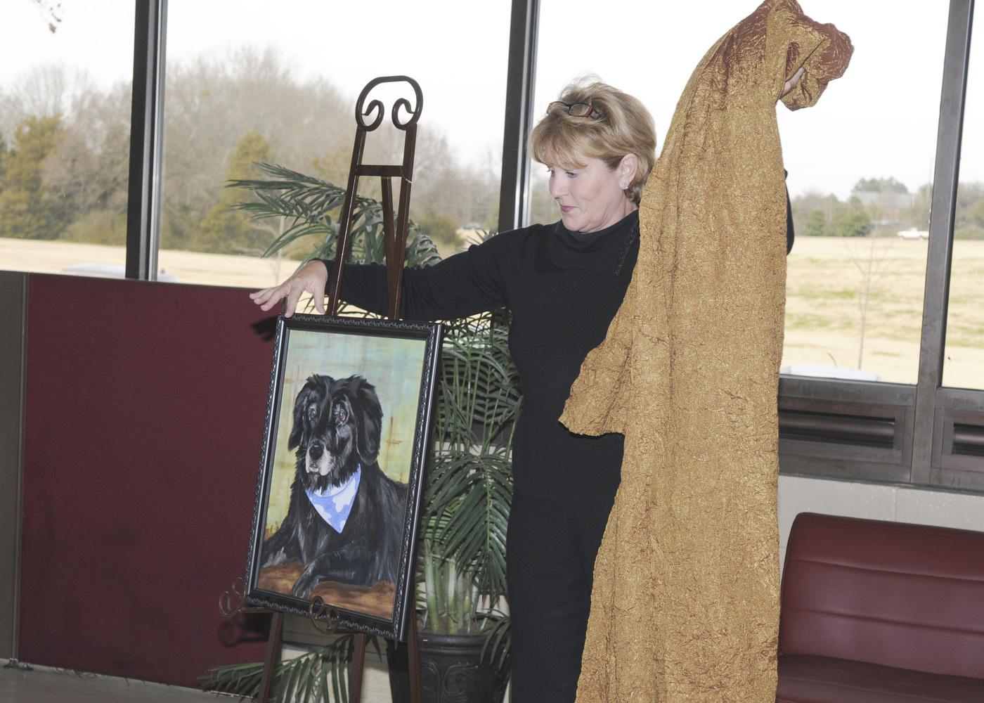 Columbus resident Terry Brewer unveils a portrait of her 15-year-old dog, Abby, that she commissioned in honor of faculty, students and staff at Mississippi State University's College of Veterinary Medicine. The portrait will hang in the Small Animal Clinic's reception area. (Photo by Tom Thompson)  