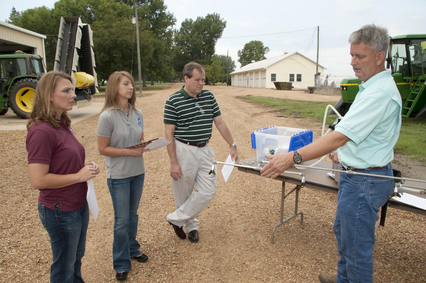 A Mississippi State University Extension Service team gets a				crash-course in how sprayers work from Dan Reynolds. From left, Jamie Varner, Kelli McCarter and				Randy Loper are writing an app that will help farmers properly calibrate sprayers. (Photo by MSU Ag Communications/Kat Lawrence)