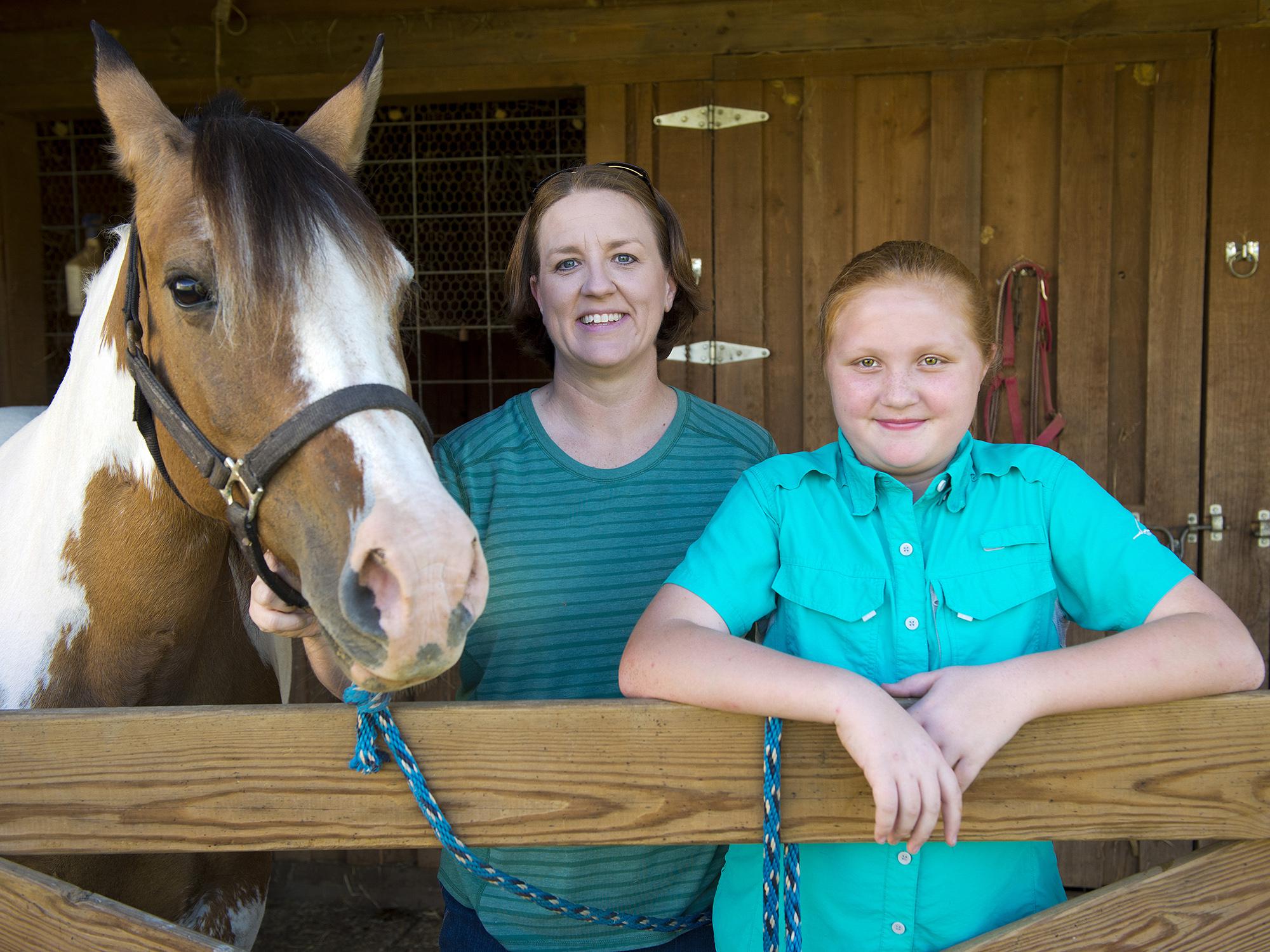 A young girl and her mother are pictured with their horse.