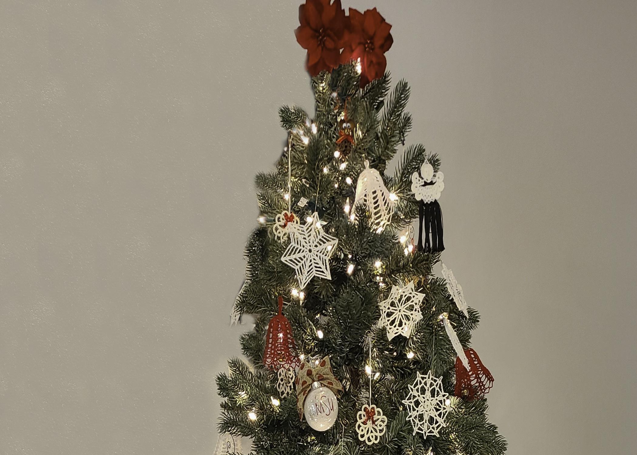 A Christmas tree is hung with red and white ornaments.