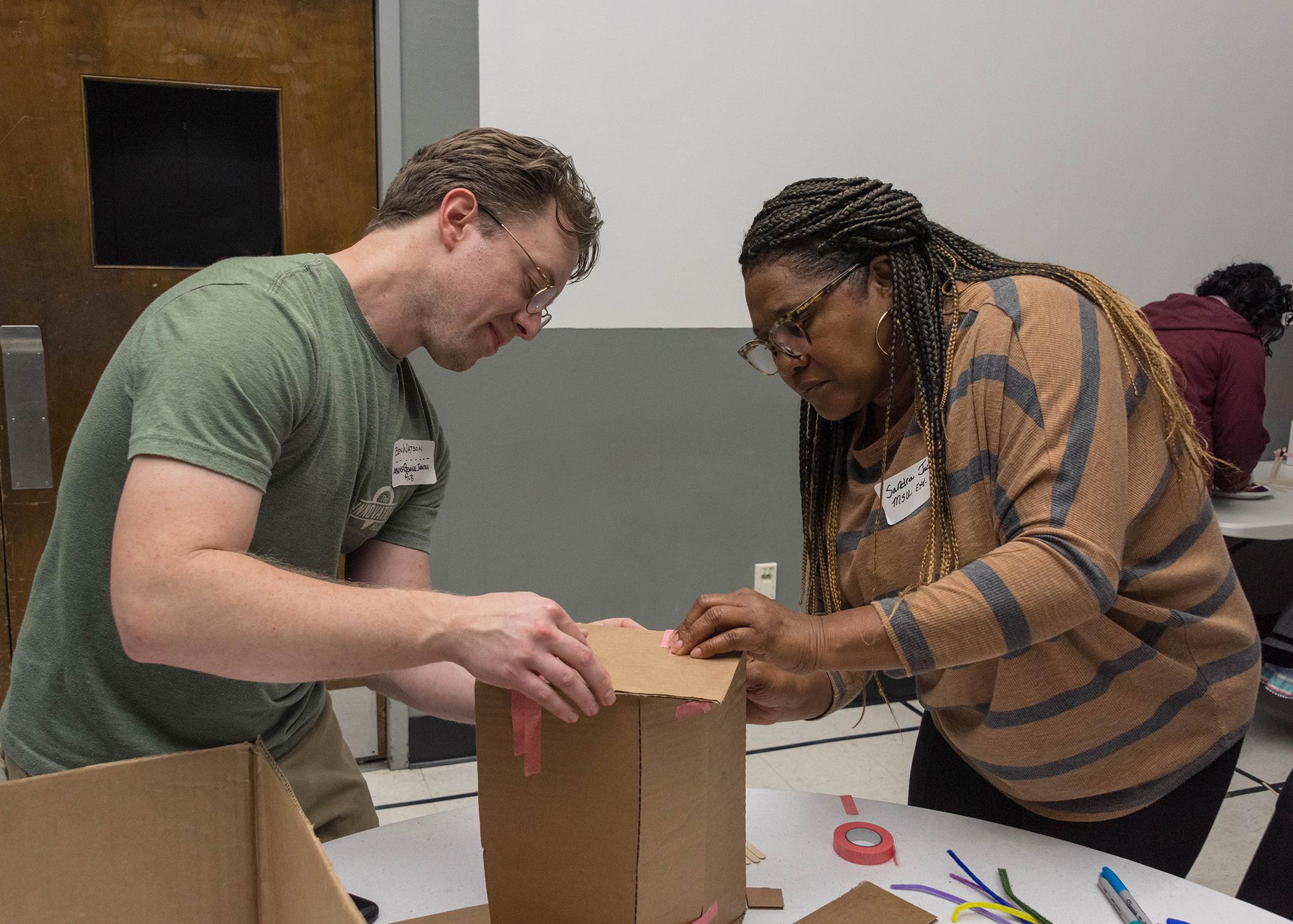 A man and a woman work together with a box.