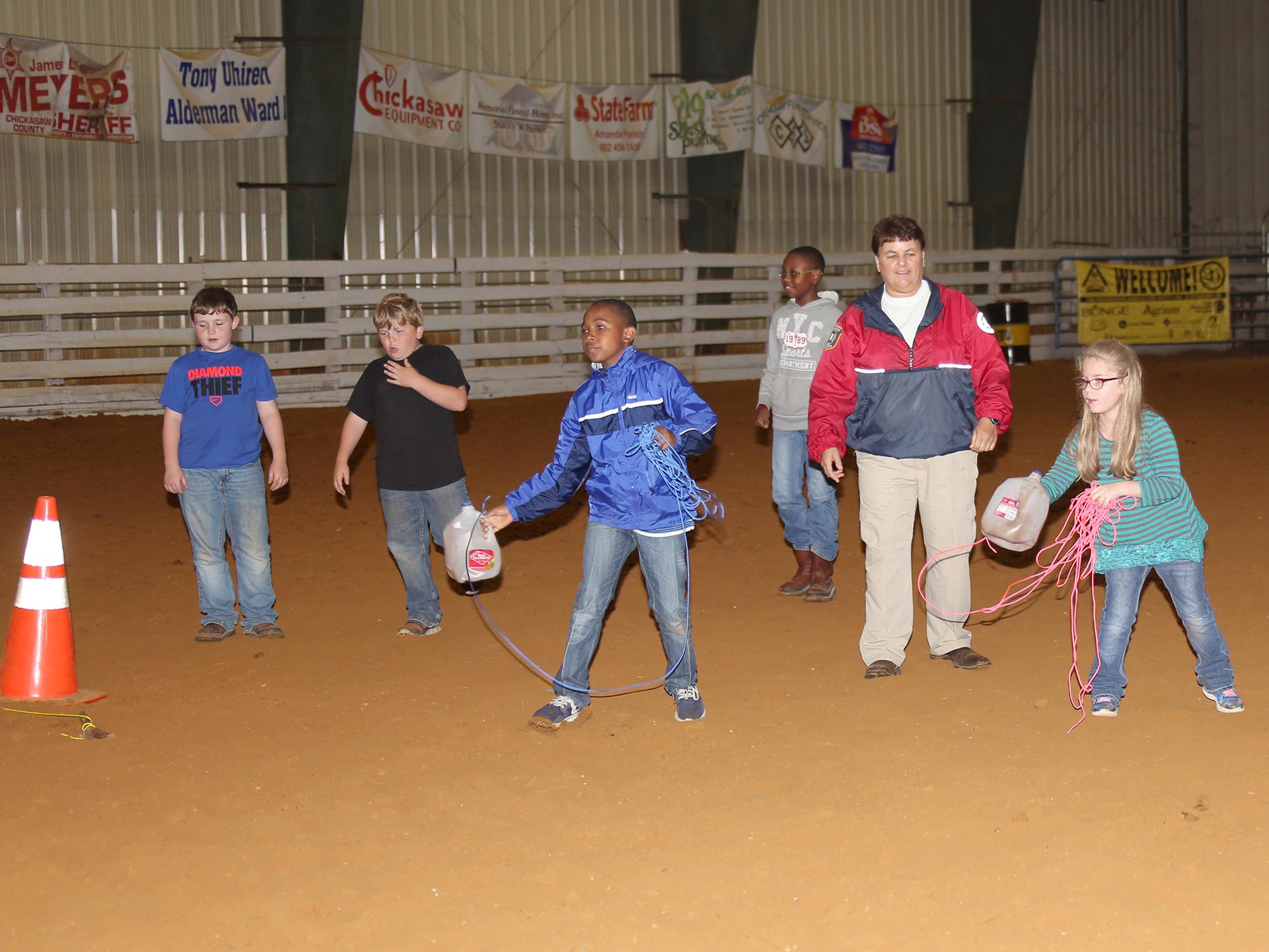 Chickasaw County Emergency Management Agency Director Linda Griffin, second from right, teaches 4-H members how to use found objects to save someone who is drowning during a meeting of the 4-H sportfishing club April 14, 2016, at the Chickasaw County Agricenter. (Photo by MSU Extension Service/Kat Lawrence)