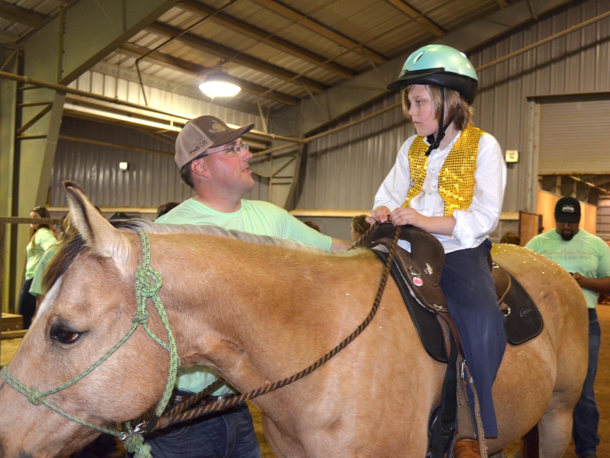 Volunteers and riders will be featured at Mississippi State University’s second annual Therapeutic Riding Expo at the Mississippi Horse Park on April 19. This file photo shows Lantz Stewart of West Point offering advice to Eli Barlow before they enter the arena for the first riding exposition in 2015. (Photo by MSU Ag Communications/Linda Breazeale)