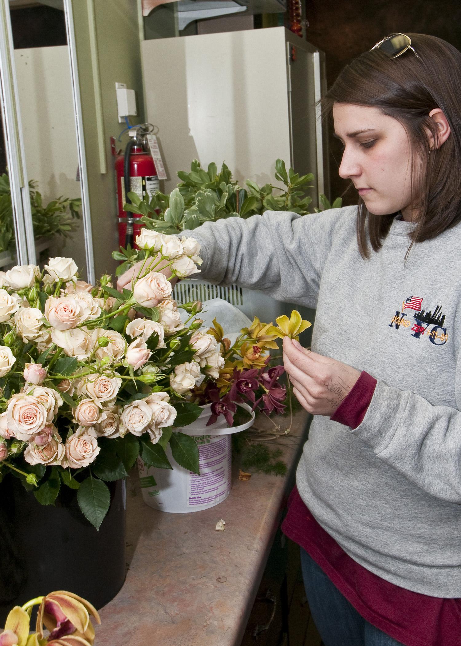 A good florist will help make decisions on what flowers and colors to include in a wedding. Here, Mississippi State University senior Meryl Williams of Columbus selects flowers and foliage for a corsage project in her wedding floral design class. (Photo by MSU Ag Communications/Scott Corey)