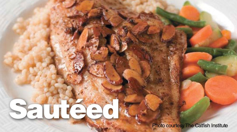 Close-up of cooked, seasoned catfish served on a plate with quinoa and steamed carrots and green beans.