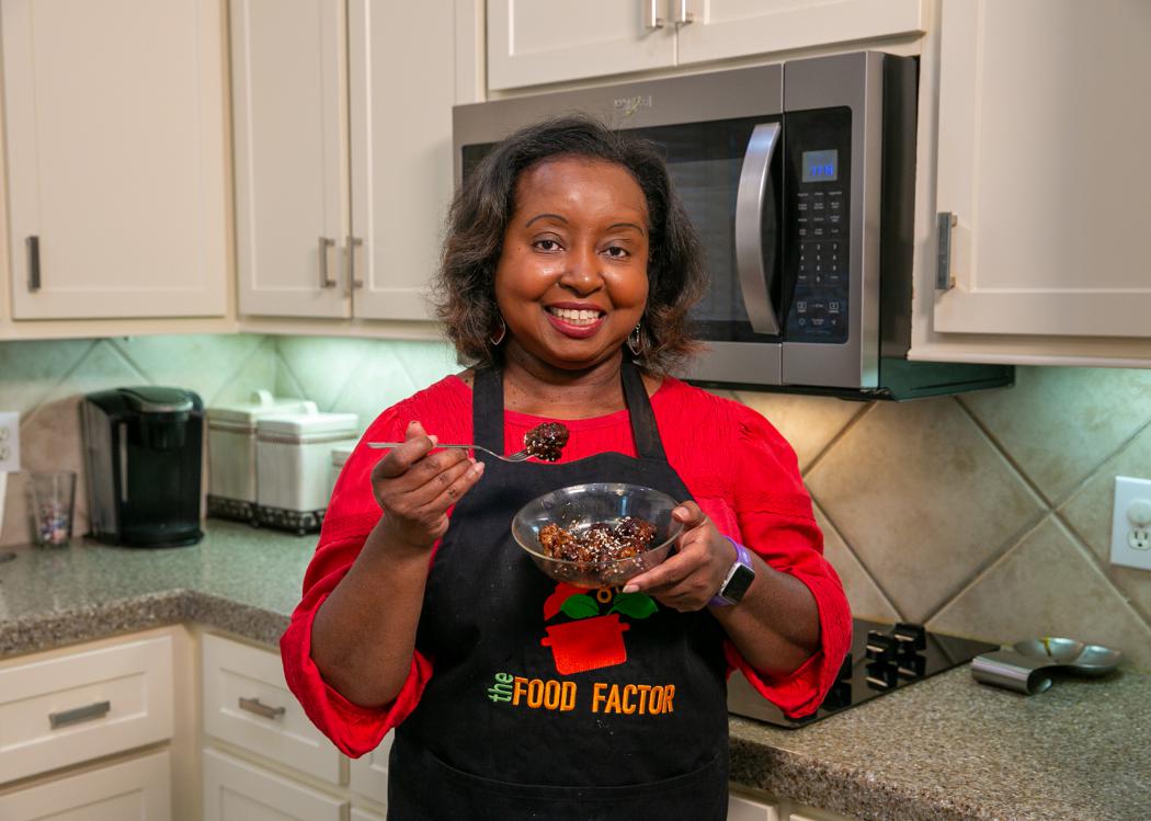 A woman holds a bowl of Teriyaki Meatballs.