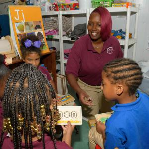 A woman interacting with four children.