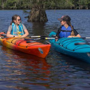 Two girls wearing life jackets.