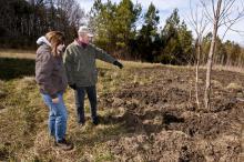 USDA Mississippi Wildlife Services Director Kris Godwin and Paul Sellars, a tree farmer in Oktibbeha County, assess damage on Sellars' property caused by wild pigs. The pigs' deep rooting has made it difficult for Sellars to maintain parts of his land. (Photo by Scott Corey)