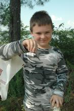 Corran Hall , 9, a fifth grader from Des Moines, Iowa, displays a dragonfly he caught during the insect and plant ecology camp at Mississippi State University.