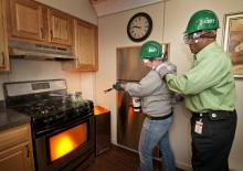 Donna Adams (left), area coordinator for Mississippi State University's student housing, and Calvin Mosley, associate director of student housing, extinguish a simulated fire in a trailer specifically designed for teaching fire control skills. Adams and Mosley are part of a group of 28 faculty and students who participated in MSU's Campus Community Emergency Response Team training. The CERT program educates people about disaster preparedness for hazards that may impact their area. The Nov. 8 training was ad