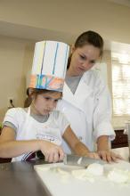 Camper Kendall Willeford of Starkville and Kristin Weaver of Byhalia, a student in the Food Science, Nutrition and Health Promotion program at Mississippi State University, prepare the ingredients for a dish during Fun with Food. (Photo by MSU Ag Communications/Kat Lawrence)