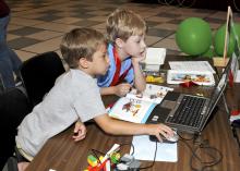 Ethan Hicks and Eric Mellin of Starkville follow instructions to program the soccer goalie robot they built at the Cloverbud Camp held at Mississippi State University. (Photo by MSU Ag Communications/Scott Corey)