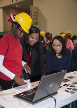 I-Wei Chu, with Mississippi State University's Institute for Imaging and Analytical Technologies, helps Biloxi Junior High School eighth-grader, Danaisha Cherry, and her mother, Lydia Cherry, look at some images with a scanning electron microscope during the Pathways2Possibilities career expo Nov. 13. More than 6,000 eighth-graders participated in the two-day event at the Mississippi Coast Coliseum and Convention Center in Biloxi. (Photo by MSU Ag Communications/Kat Lawrence)