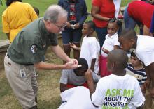 George Phillips, paleontology curator with the Mississippi Museum of Natural Science, describes a fossil found by this group of BioBlitz attendees Sept. 13, 2014, on the grounds of the museum. The BioBlitz event brought together students, teachers, community members and scientists to inventory the area's biodiversity and spark interest in ecology. (Photo by MSU Ag Communications/Kevin Hudson)