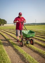 Barry Stewart, turf management specialist with the Mississippi Agricultural and Forestry Experiment Station, demonstrates fertilizing equipment on Aug. 29, 2013, on a recently cut patch of St. Augustine grass grown at Mississippi State University's R.R. Foil Research Center. (Photo by MSU Ag Communications/Scott Corey)