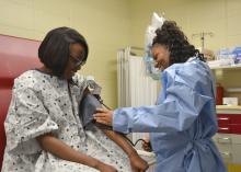 Brittny Fairley, right, checks Dequesia Perry’s blood pressure in their health science class at the Hinds County Career and Technical Center in Raymond, Mississippi, on May 4, 2017. They are members of the Mississippi State University Extension Service 4-H Junior Master Wellness Volunteers group in Hinds County who received training to deliver basic health information and provide supervised basic screenings. (Photo by MSU Extension Service/Susan Collins-Smith)