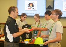 Ryan Akers (left), an assistant Extension professor in the Mississippi State University School of Human Sciences, helps 4-H members examine items in a disaster preparedness backpack. Madison Crawford (second from left) and Leigh Anne Walley, both of Greene County, joined Caleb Walley and Bo Henderson, both of Wayne County, in the workshop on June 1 at the 2017 State 4-H Congress in Starkville, Mississippi. (Photo by MSU Extension Service/Linda Breazeale)