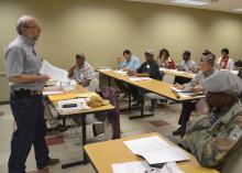 A Mississippi State University specialist stands before a room of seated meeting participants.