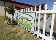 Colorful flowers are planted next to a sign at the entrance of the North Bay Elementary School garden.