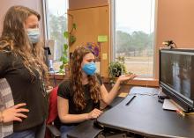 Two women work in an office setting.