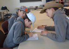 Young people work on a written task in a classroom.
