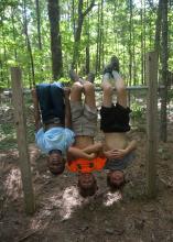 Imitating bats that like to hang upside down is a fun activity for children as they explore a nature trail at St. Catherine Creek National Wildlife Refuge near Natchez, Mississippi, on July 7, 2016. (Photo by MSU Extension Service/Linda Breazeale)
