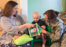 Heather Bond (left) plays with Thaddeus Pyko, while his mother, Maj. Kyla Pyko, watches. Bond is a family-home care provider who has opened her home to military families needing child care.  (Photo by MSU Extension Service/Alexandra Woolbright)