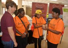 Union County Extension agent Gina Wills, left, watches as India Hamilton, Kaitlyn McGee and Ja’vonne Rich examine a newly hatched chick at the poultry booth on Oct. 5, 2016, at a career expo for eighth-graders in Tupelo, Mississippi. The three students, all from Armstrong Middle School in Starkville, Mississippi, were among 7,000 students taking part in the event sponsored by the CREATE Foundation Toyota Wellspring Education Fund and many other individuals, companies and civic organizations. (Photo by MSU E