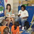 Mississippi State University health promotion graduate student Katie Shumpert and nutrition undergraduate student Latossia Clark show preschoolers examples of nutritious fruits and vegetables. (Photo by Chiquita Briley/MSU Department of Food Science, Nutrition and Health Promotion)