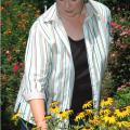 Rankin County Master Gardeners president Nellie Axley of Brandon admires the refurbished flower bed the group created for the local Extension office landscape.