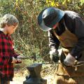 Fourth-generation blacksmith Chuck Averett helps Morgan Alexander make an arrowhead at the Piney Woods Heritage Festival held Nov. 16 and 17 at Mississippi State University's Crosby Arboretum. (MSU Ag Communications/Susan Collins-Smith)
