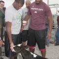 Quadry Antoine of Belle Chase, La., Rufus Warren of Indianola, and other members of Mississippi State University's football team play with a calf at the third annual Beefing Up the Bulldogs event at MSU on Aug. 18, 2013. (Photo by MSU Ag Communications/Kat Lawrence)