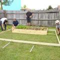 Gary Bachman, horticulture expert with Mississippi State University, provides guidance to the "Ask This Old House" crew, including (from left) producer Heath Racela, landscape contractor Roger Cook, director Thomas Draudt and grip Sean Finnegan. The traveling home improvement show filmed the installation of a backyard high tunnel in Biloxi on Oct. 9. (Photo by MSU Ag Communications/Susan Collins-Smith)