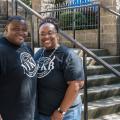 A man and woman standing in front of steps, smiling.