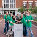 Students in green shirts posing for a picture. 