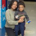 A mother embraces her son in a school hallway.