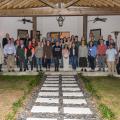 A large group of people standing on a covered patio.