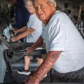 A smiling person walking on a treadmill.