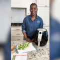 A woman in a kitchen with an air fryer.