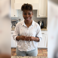 A woman stands in a kitchen.